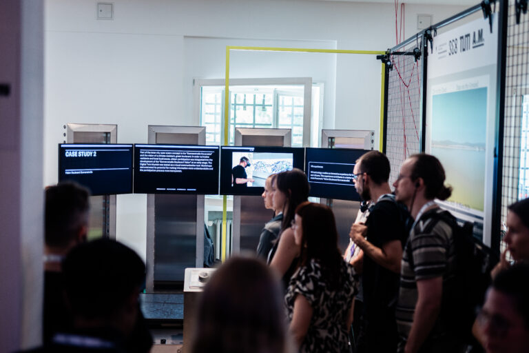 Besuchende betrachten Bildschirme die Content zu einer Case Stuy zeigen, der Installation Mobile Data Soil von 3e8 beim Festival der Zukunft in München