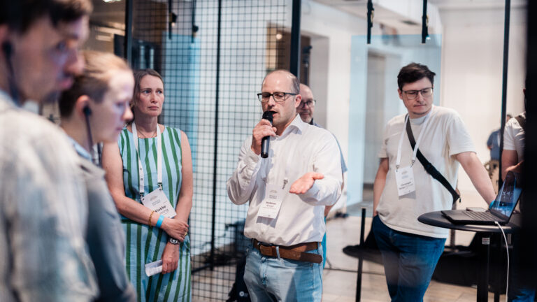 Referent erklärt Besucher:innen die interaktive Installation Mobile Data Soil von 3e8 beim Festival der Zukunft in München