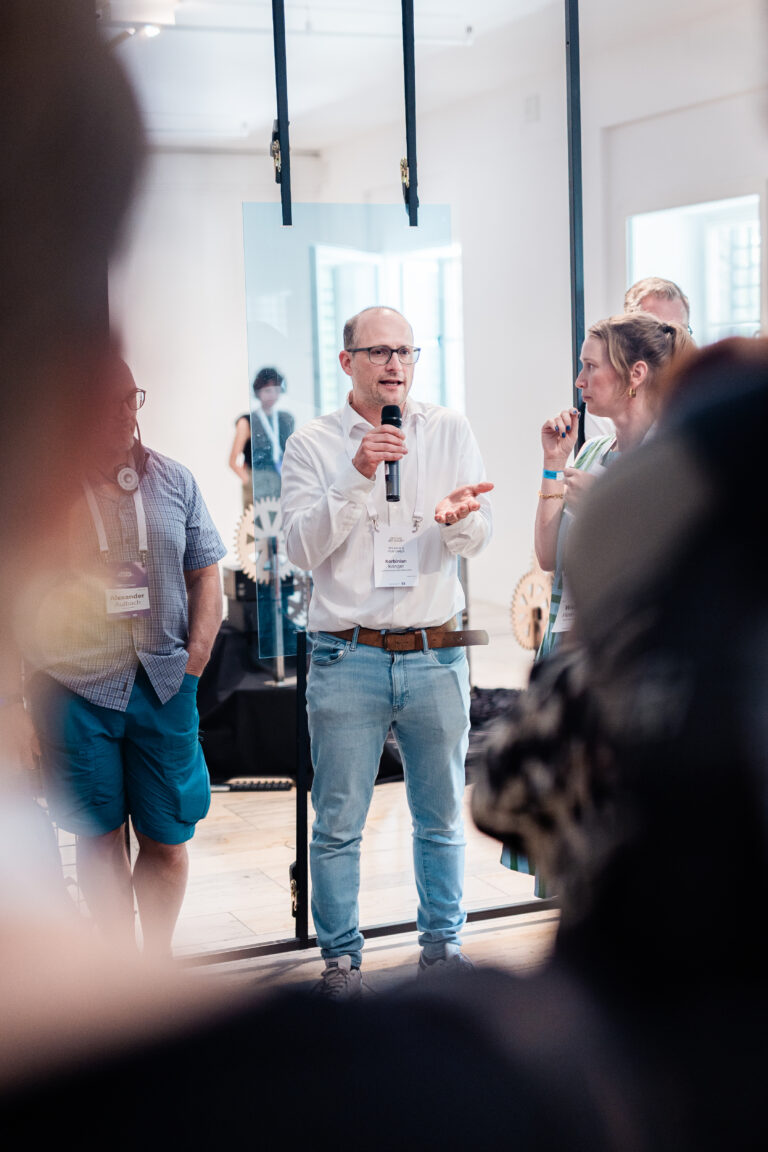 Referent erklärt Besucher:innen die interaktive Installation Mobile Data Soil von 3e8 beim Festival der Zukunft in München