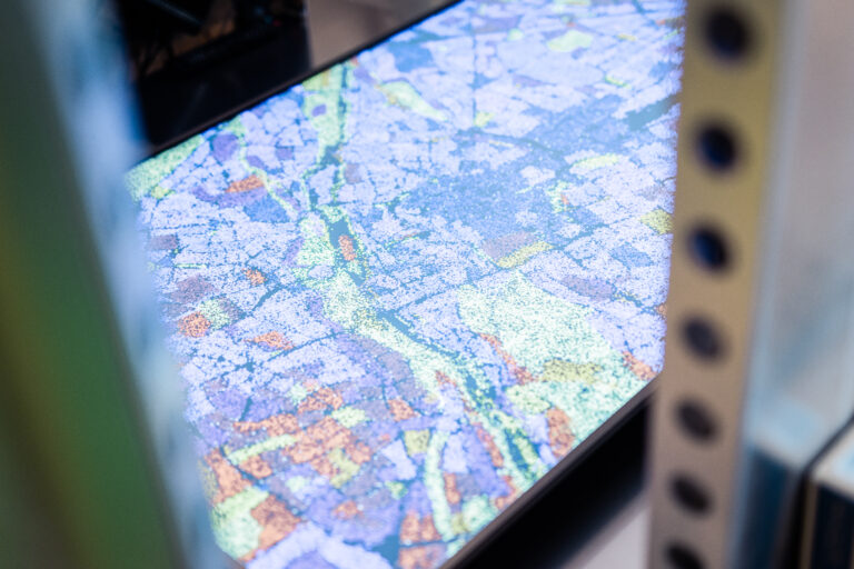 Nahaufnahme der farbigen Datenvisualisierung in Form eines Patikelsystems auf dem Bildschirm der Installation Mobile Data Soil von 3e8