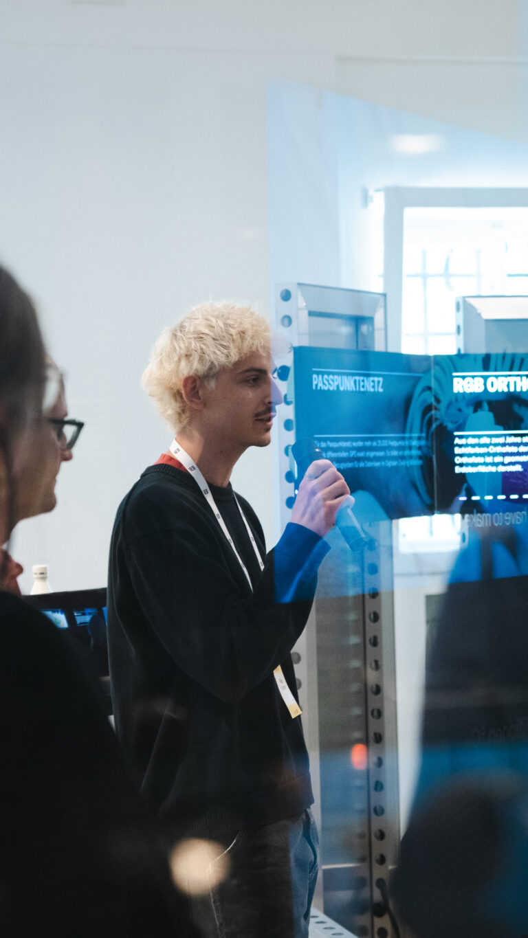 Referent erklärt Besucher:innen die interaktive Installation Mobile Data Soil von 3e8 beim Festival der Zukunft in München